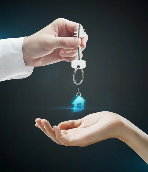 Man is handing a house key to a woman — Stock Photo, Image