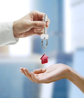 Man is handing a house key to a woman.