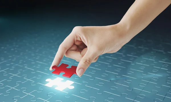 Hand embed missing puzzle piece into place. — Stock Photo, Image