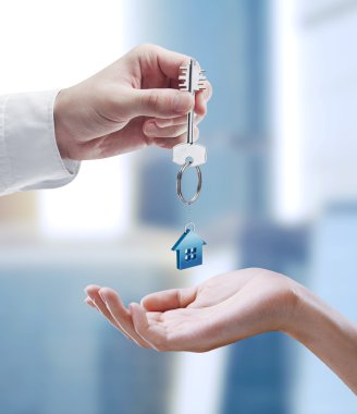 Man is handing a house key to a woman. clipart