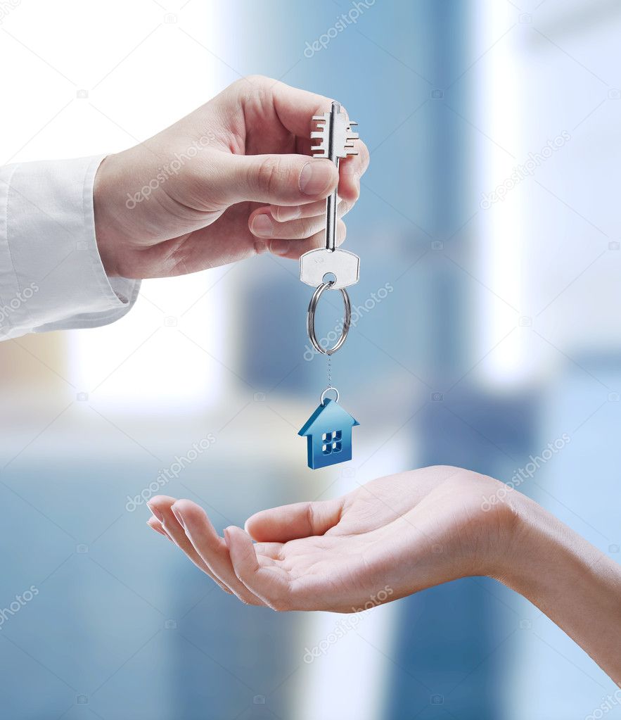 Man is handing a house key to a woman.