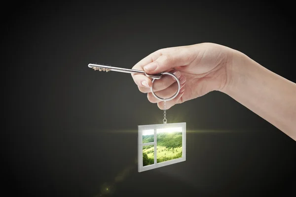 stock image Hand holding key with a keychain in the shape of the window