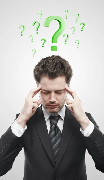 stock image Portrait of a young man with green question marks above his head.