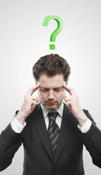 Retrato de un joven con signo de interrogación verde sobre su cabeza . — Foto de Stock
