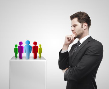 Young businessman look at the group of social on a white pedestal. clipart