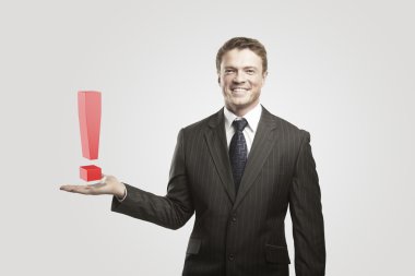 Young businessman with an exclamation mark on his hand. clipart