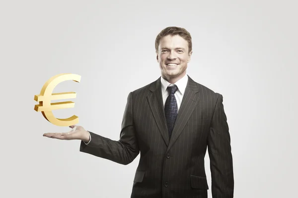 Jovem empresário escolhe um sinal de ouro Euro . — Fotografia de Stock