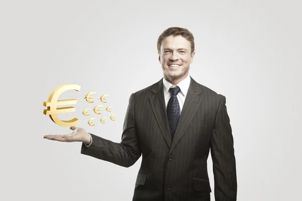 Молодой бизнесмен выбирает золотой знак евро — стоковое фото