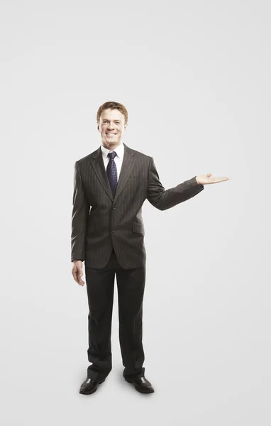 空の手で何かを提示する若いビジネスマンの笑みを浮かべてください。. — Stockfoto