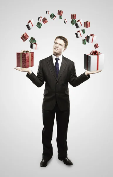 Joven hombre de negocios con cajas de regalo en sus manos . — Foto de Stock