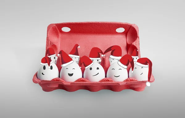 Groupe d'œufs heureux habillés en chapeaux rouge-blanc du Père Noël . — Photo