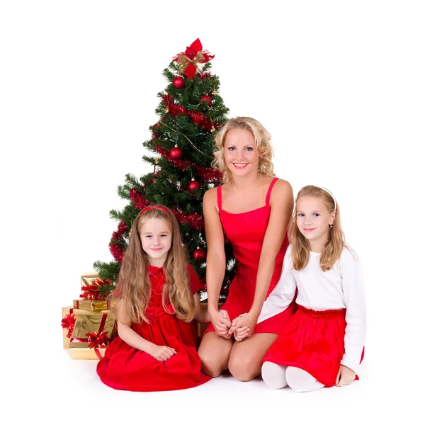 Madre con los niños se sientan cerca del árbol de Navidad . —  Fotos de Stock
