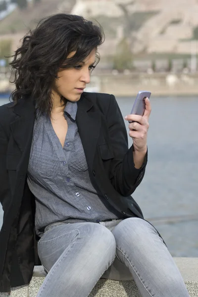 Mujer joven envía un mensaje de texto —  Fotos de Stock