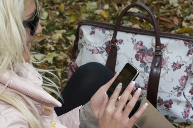 Woman with a mobile in the park