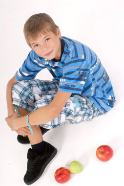 Young kid laying on the floor and 3 apples clipart