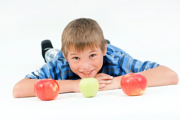 stock image Young kid laying on the floor and 3 apples