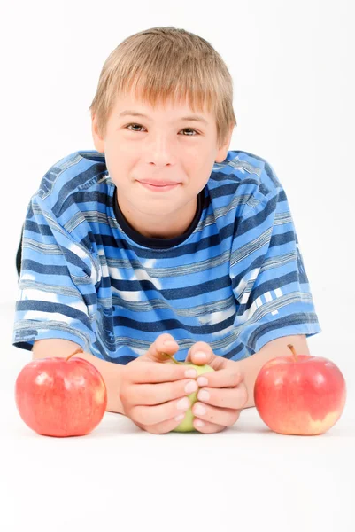 Stock image Young kid laying on the floor and 3 apples