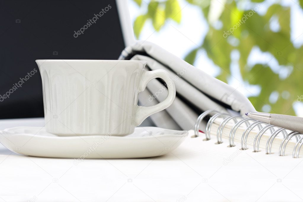Cup of coffee with office equipment