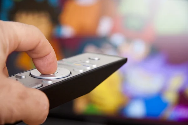Hand on the tv remote channel changing — Stock Photo, Image