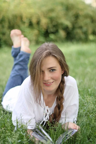 Çimenlerin üzerinde gülümseyen kız — Stok fotoğraf