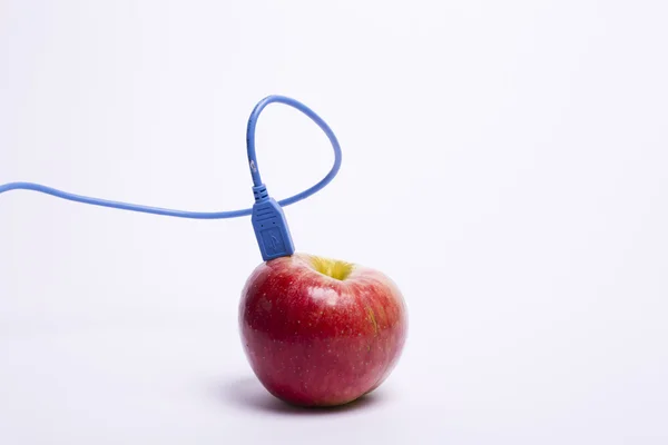 Bağlı bir usb kablosu ile kırmızı elma Stok Fotoğraf