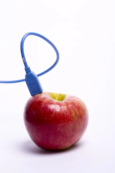 แอปเปิ้ลสีแดงที่มีสาย USB เชื่อมต่อ — ภาพถ่ายสต็อก