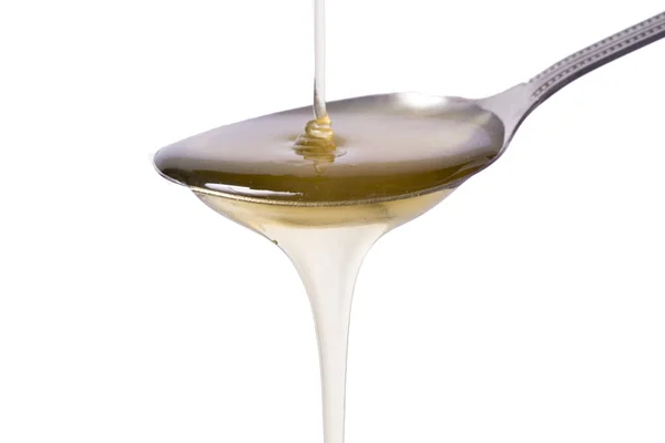 Honig in einem Löffel auf weißem Hintergrund Stockfoto
