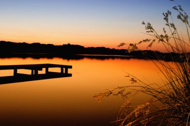 Tramonto sul lago con pontile