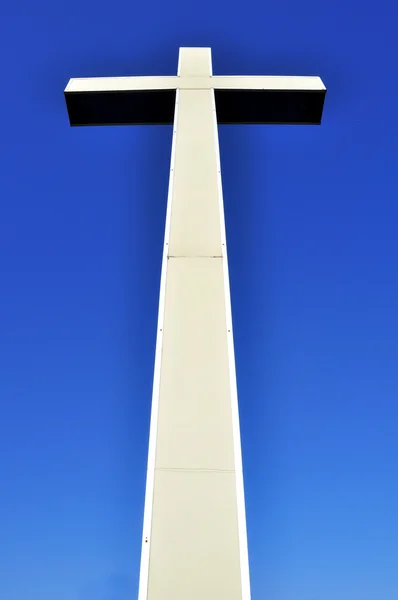 Kříž v pohledu na modré obloze — Stock fotografie