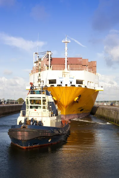 Containerschip met sleepboot boot in slot — Stockfoto