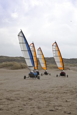 Sailing buggy at beach with blue sky clipart