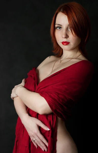 年轻红头发漂亮的女孩在一条红色的围巾 图库图片