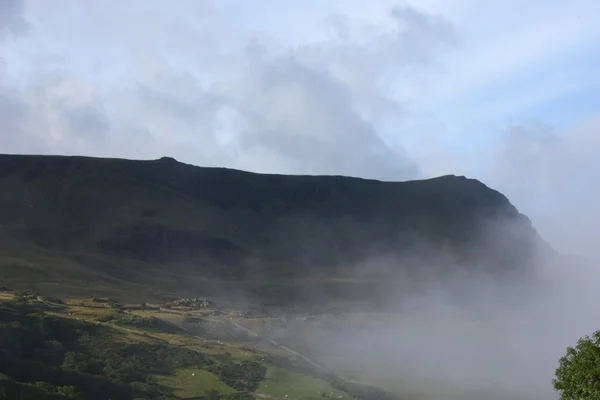 Mlha vyhrnout do údolí, zakrývající hora — Stock fotografie