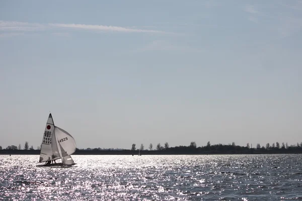 Barco navegando em um lago sob um céu de blusa — Fotografia de Stock