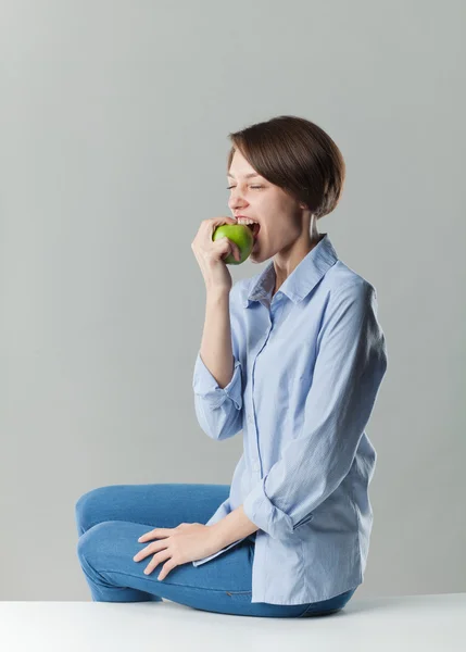 Girl eating a green apple — Stock Photo, Image