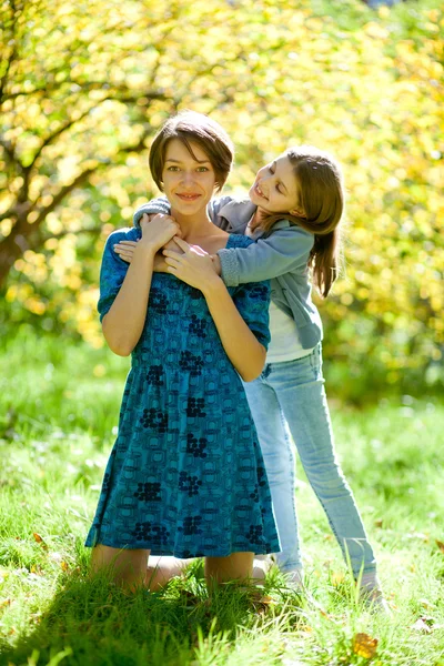Two sisters in a park in autumn — Stock Photo, Image
