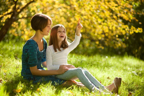 Two sisters in a park in autumn — Stock Photo, Image
