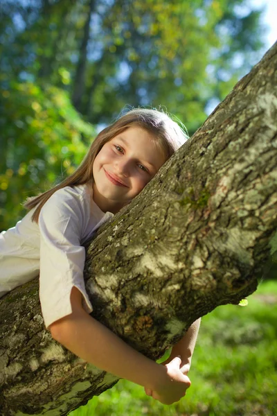 Menina deitada em uma árvore — Fotografia de Stock