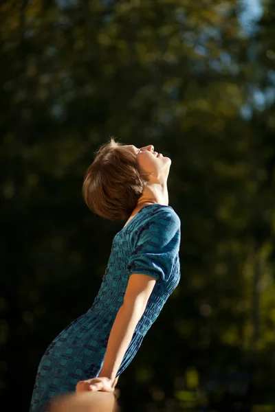 Girl stretching toward the sun smiling — Stock Photo, Image