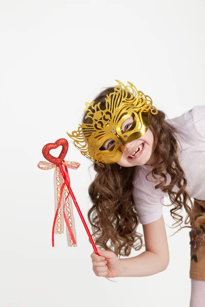 Girl in a mask and a magic wand, looking out over the edge — Stock Photo, Image