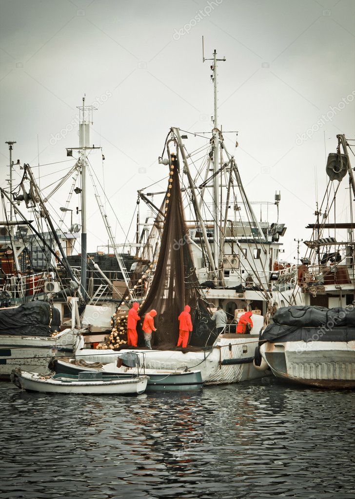 Fisherman crew fixing nets on fishing boat