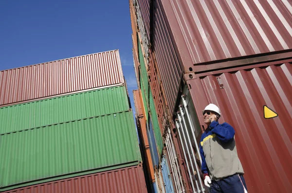Портовый рабочий и контейнеры — стоковое фото