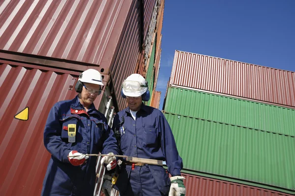 Портовые рабочие и контейнеры — стоковое фото