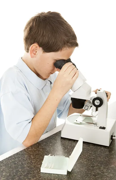 Patrząc przez Mikroskop chłopiec — Zdjęcie stockowe