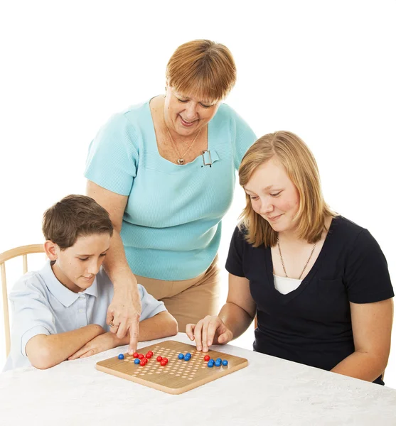 Rodinná desková hra - maminka pomáhá — Stock fotografie
