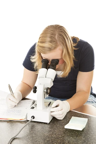 Девушка-подросток в микроскопе — стоковое фото