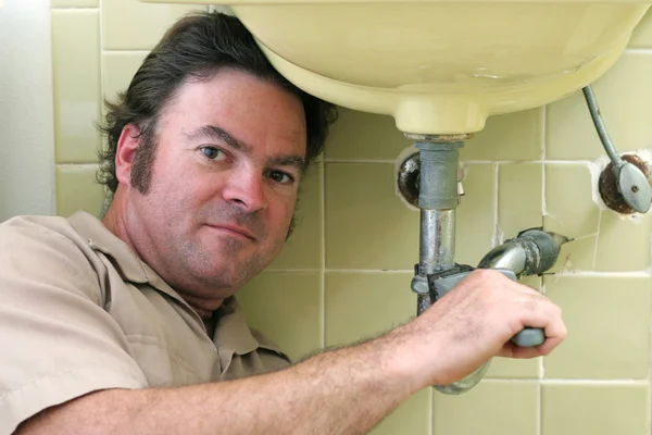 Klempner arbeitet unter Waschbecken — Stockfoto