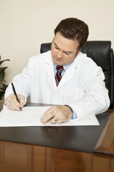 Lekarz zapisuje na wykresie — Zdjęcie stockowe