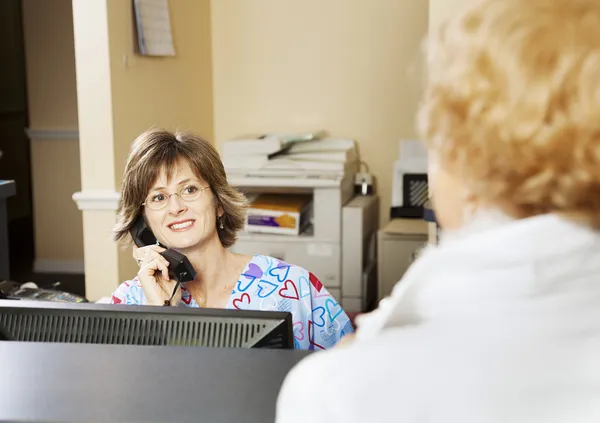 Receptionist Greets Patient — Stock Photo, Image