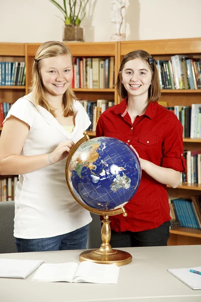 Teen dívky v knihovně s zeměkoule — Stock fotografie